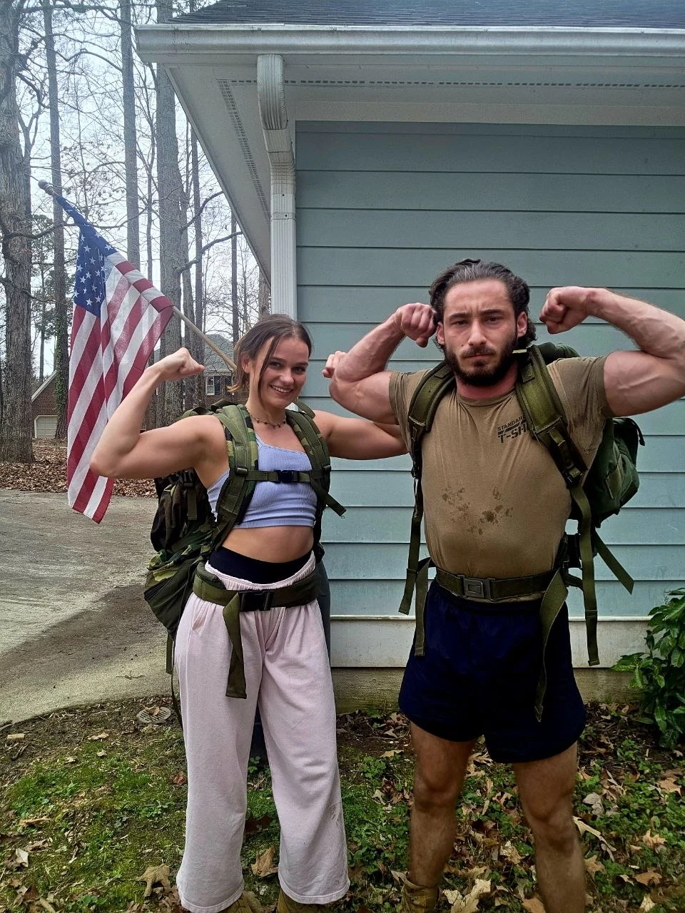 Michael and a training partner after a rucking session, packs on, flag behind them